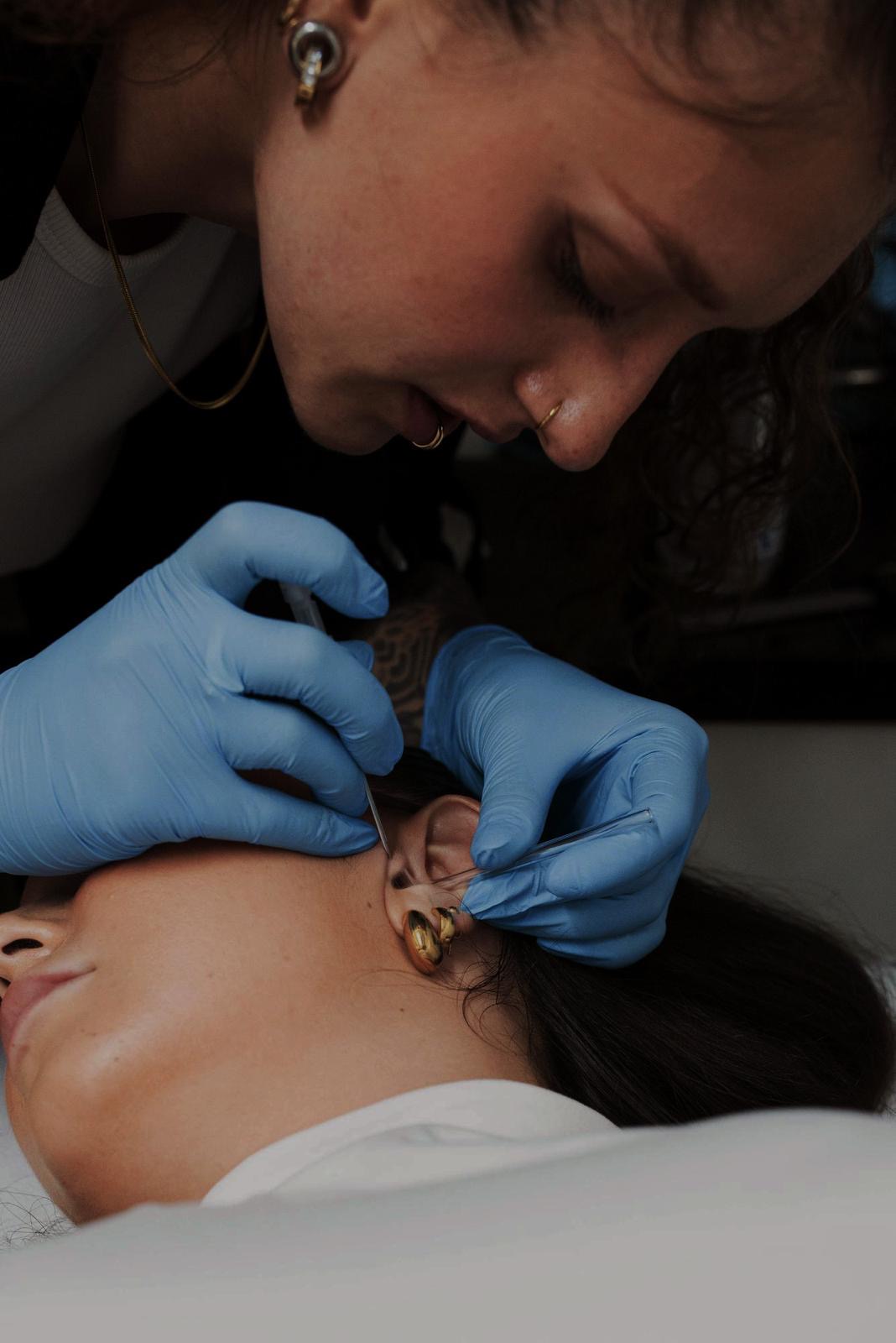 Xhenis Gega al lavoro come piercer da Happy Tattoo Club
