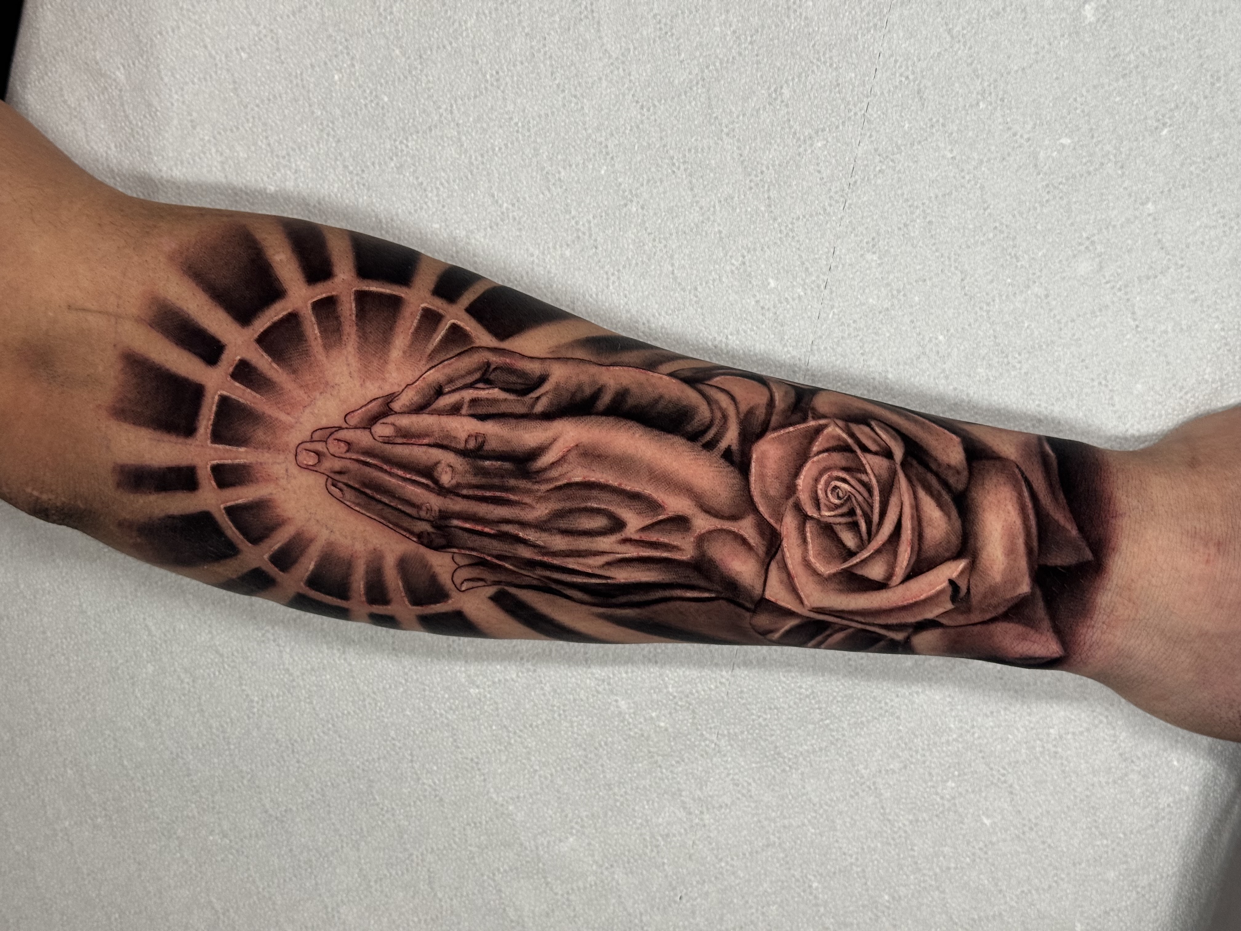 Tatuaggio realismo black and gray con orologio e fiori realizzato da Andrea N. Agnelli