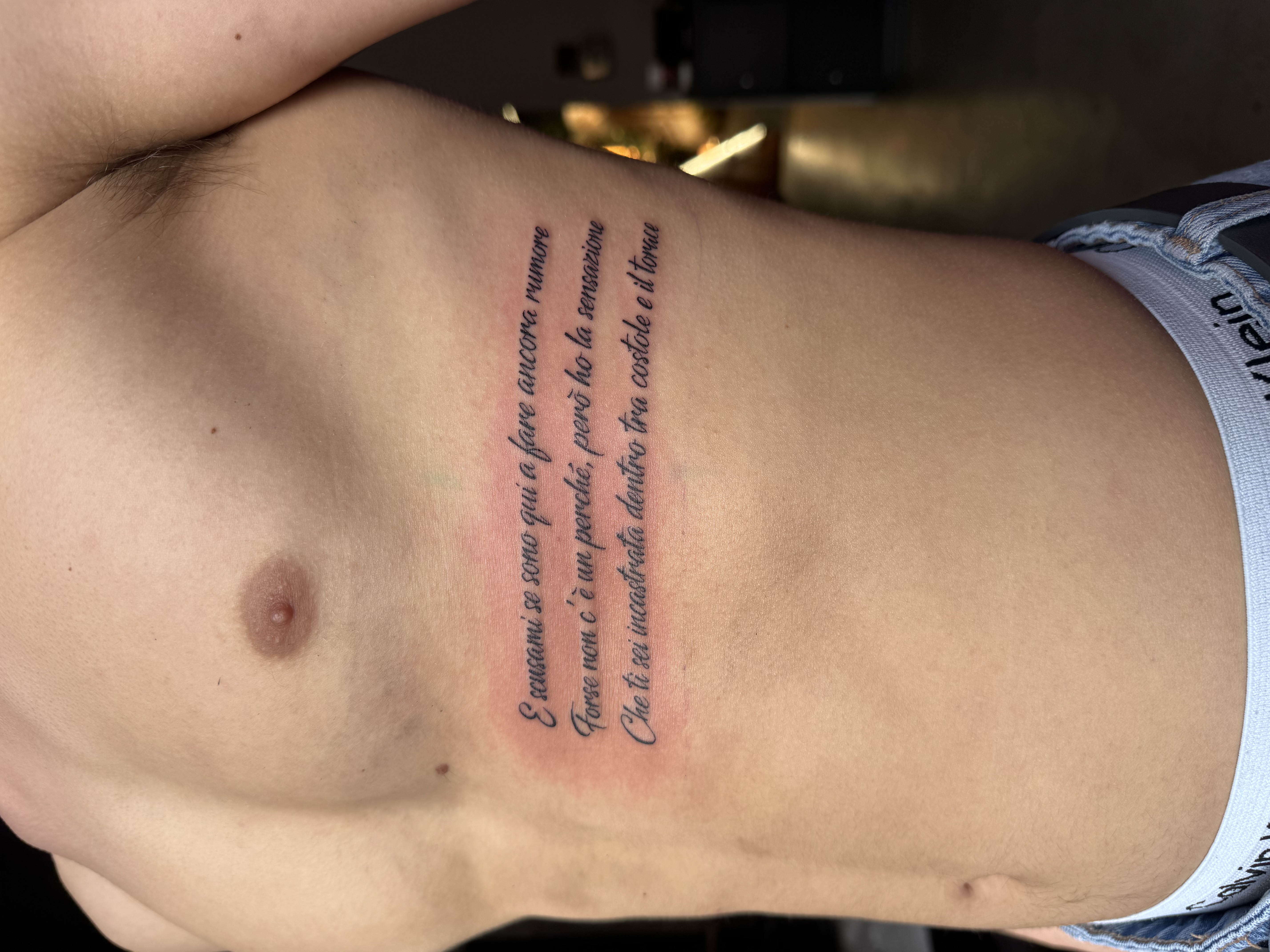 Tatuaggio frase fine line sul costato realizzato da Andrea N. Agnelli a Bra