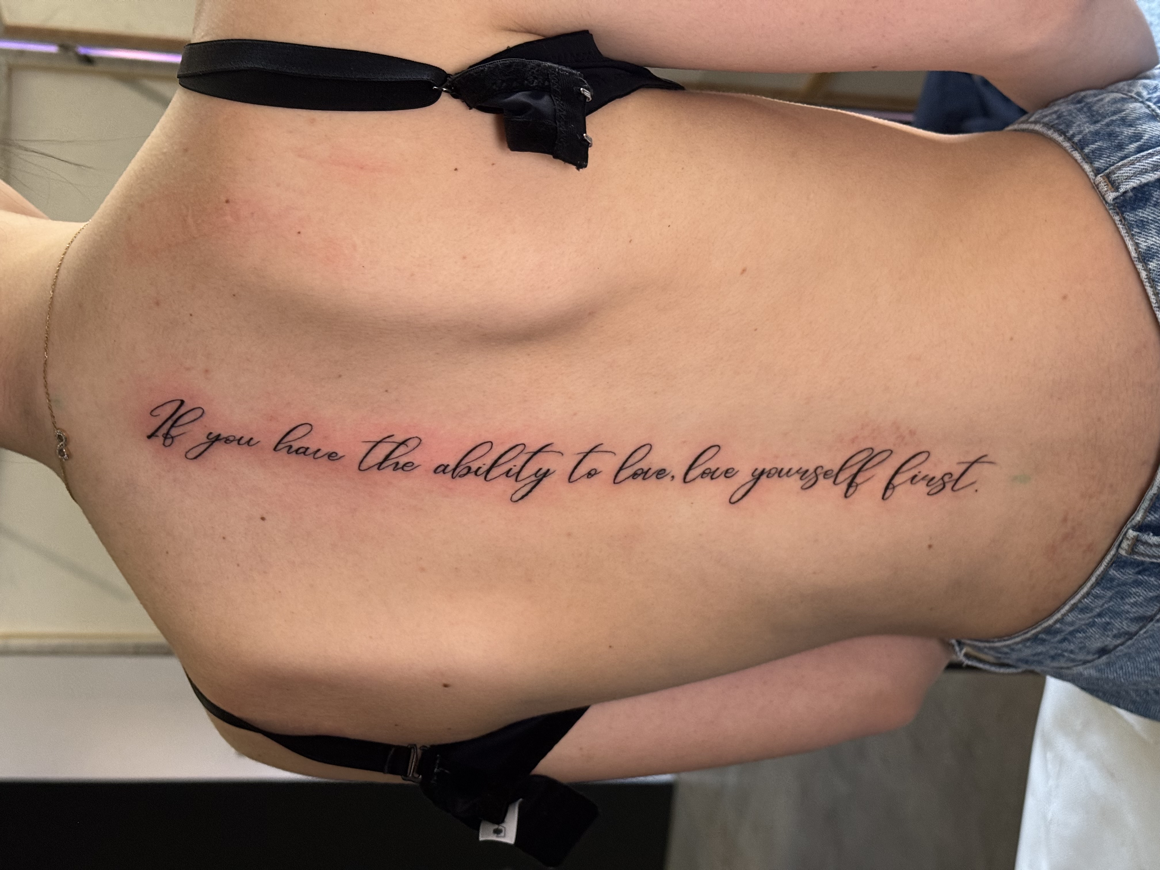 Tatuaggio fine line con scritta sul costato realizzato da Andrea N. Agnelli