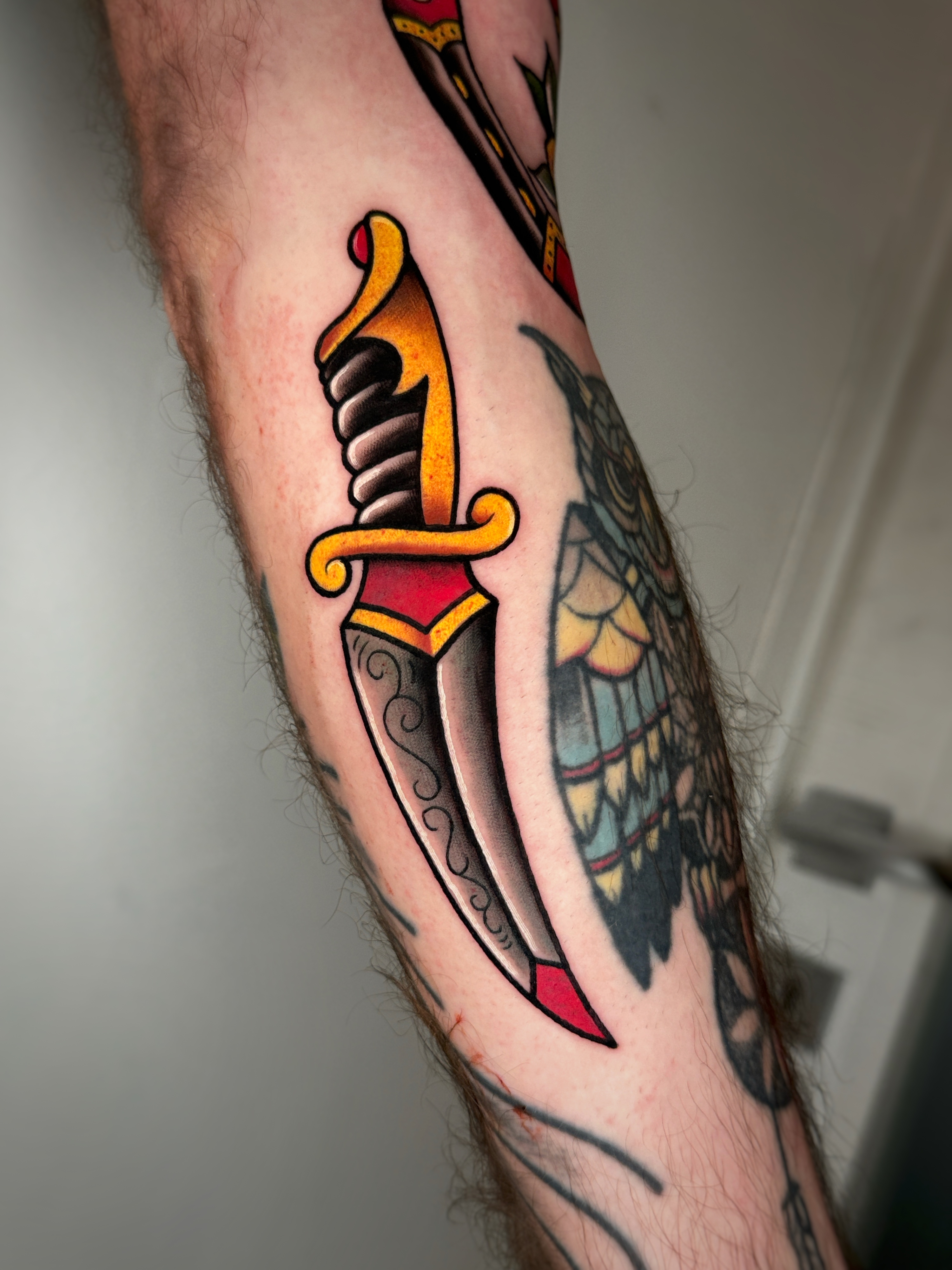 Tatuaggio a colori con pugnale realizzato da Thomas Morello AKA SAZE