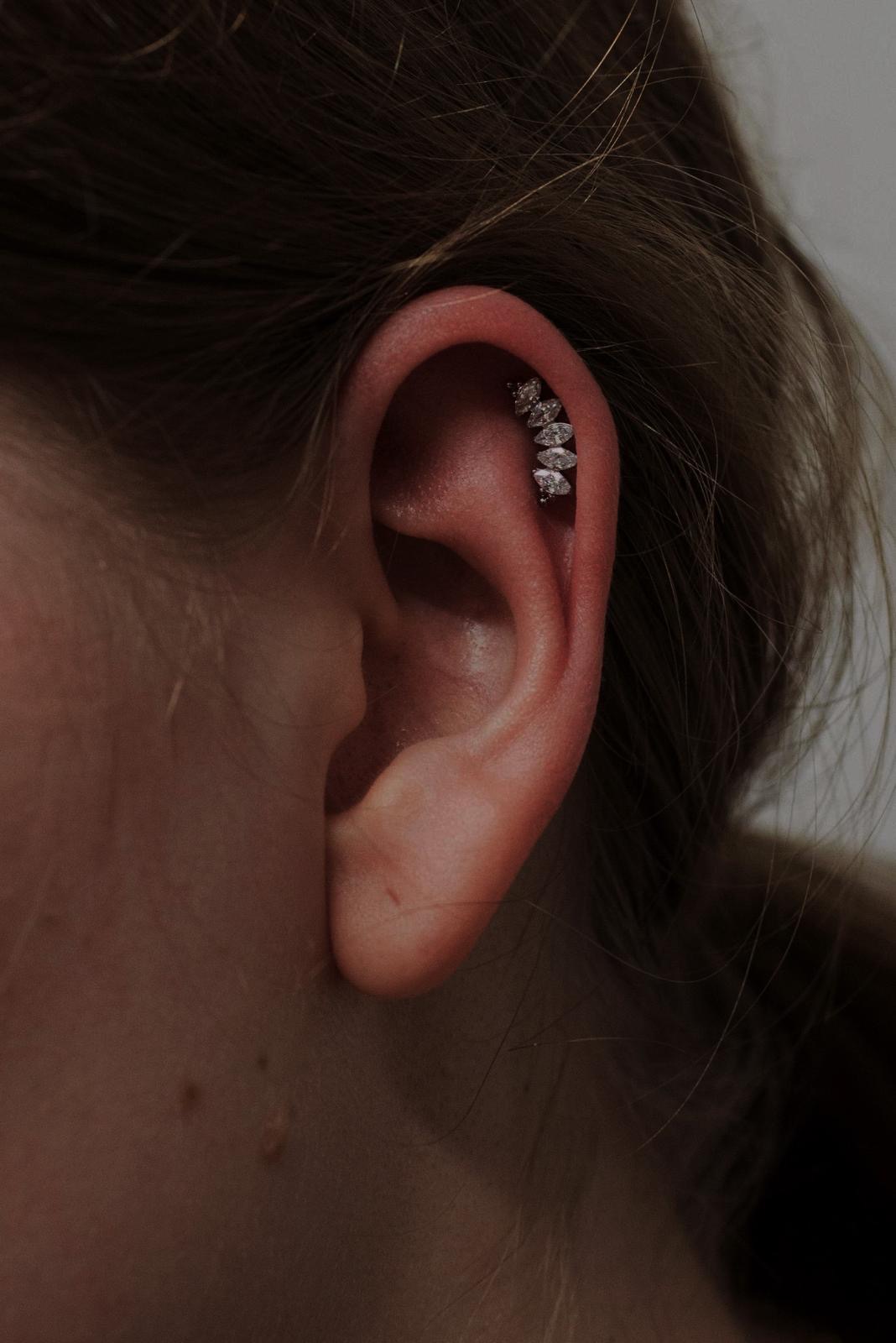 Piercing all’orecchio con gioiello decorato realizzato da Xhenis Gega