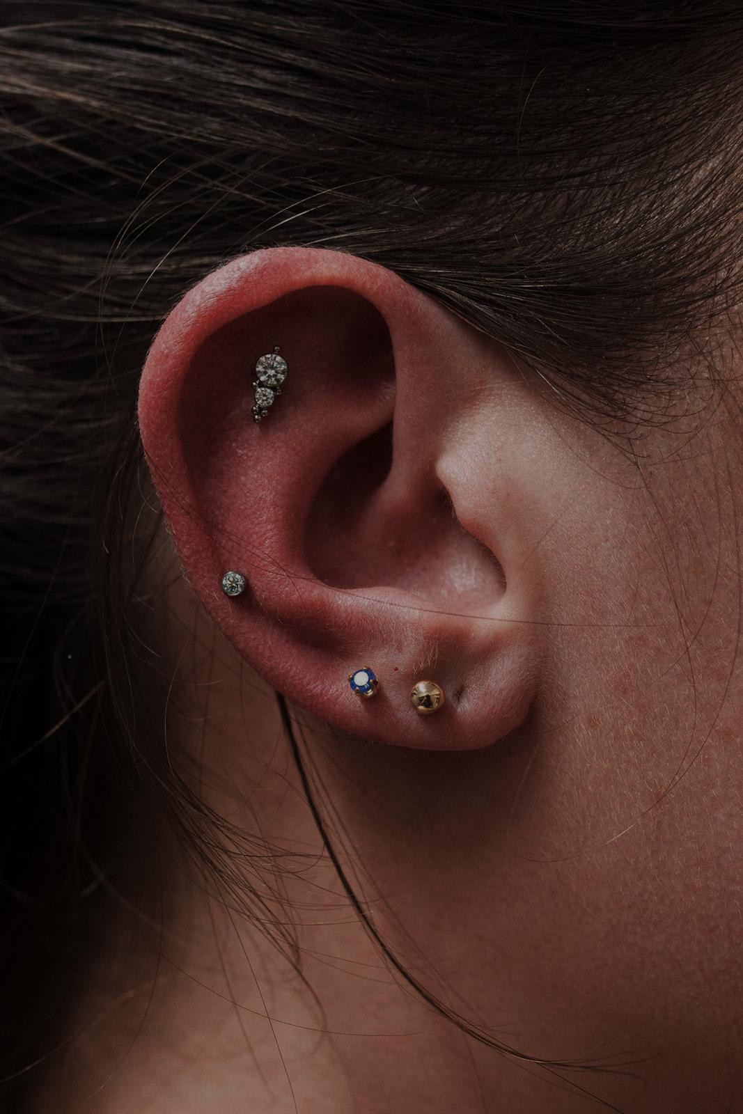 Composizione di piercing all’orecchio realizzata da Xhenis Gega