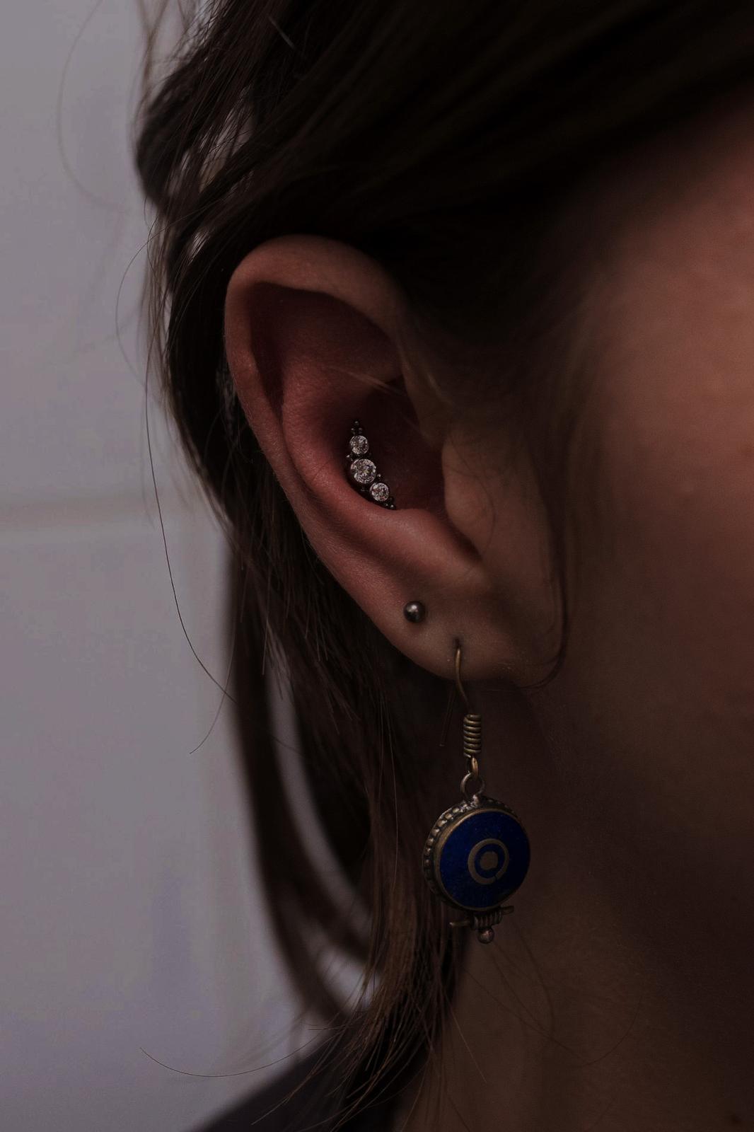 Piercing all’orecchio con gioiello decorato realizzato da Xhenis Gega