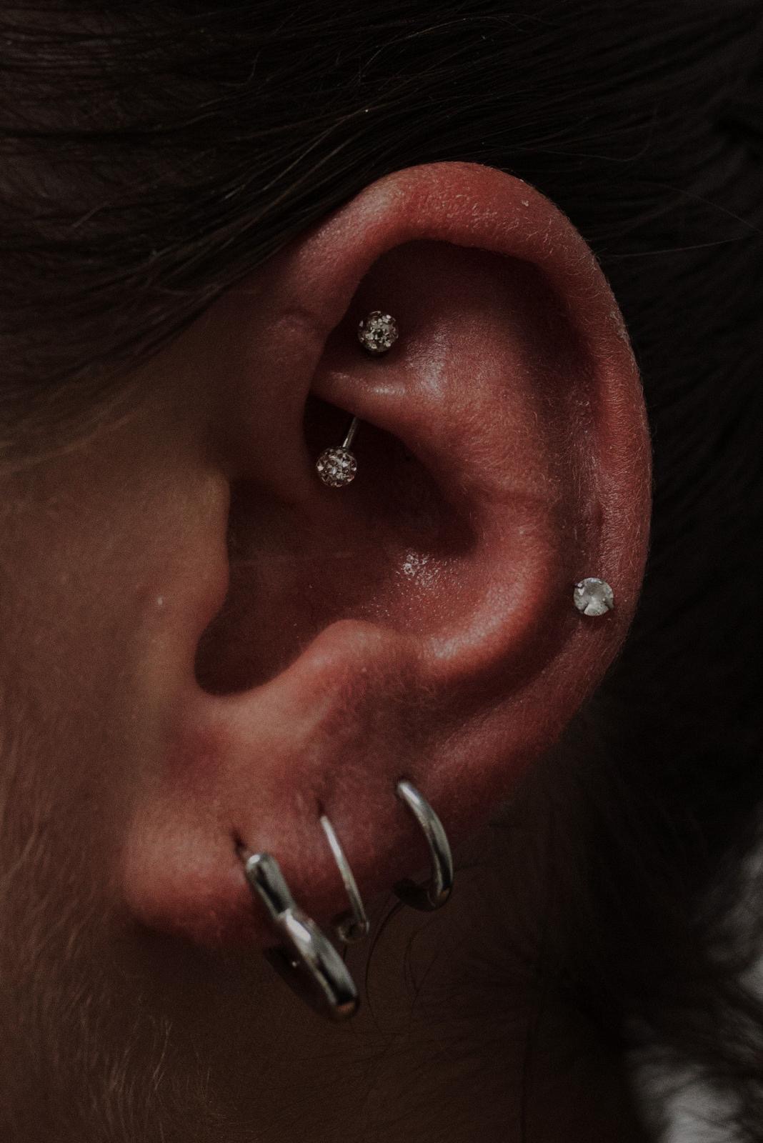 Composizione di piercing all’orecchio realizzata da Xhenis Gega